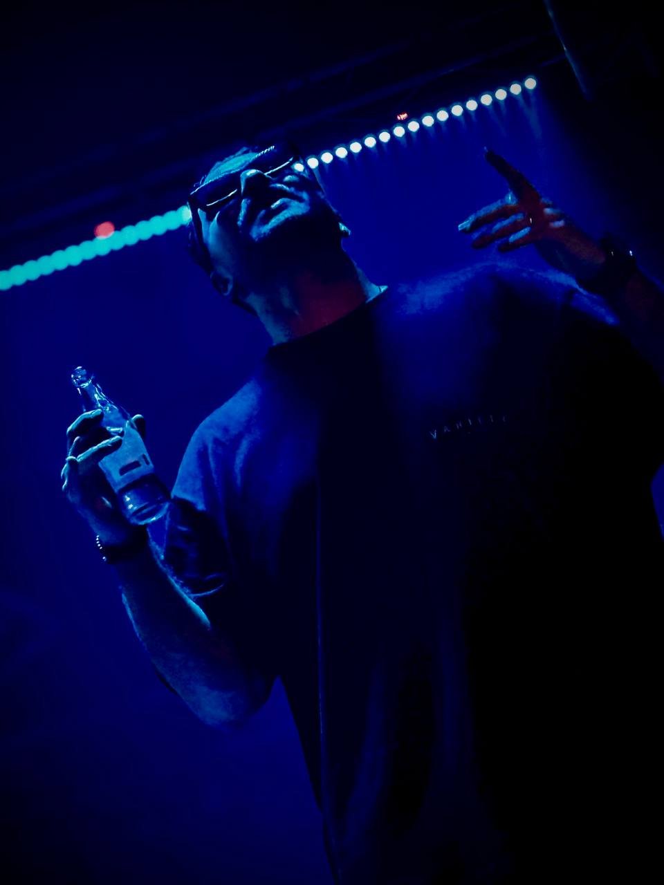 DJ Masoudi on stage in blue light